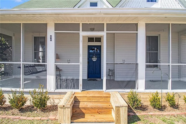 doorway to property featuring a shingled roof and a porch