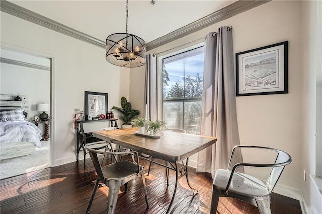 dining space featuring dark hardwood / wood-style flooring, a notable chandelier, and ornamental molding