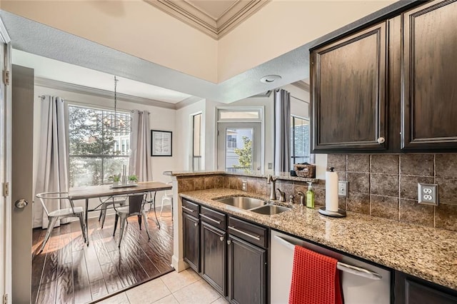 kitchen featuring sink, light stone counters, dark brown cabinets, light tile patterned floors, and dishwasher