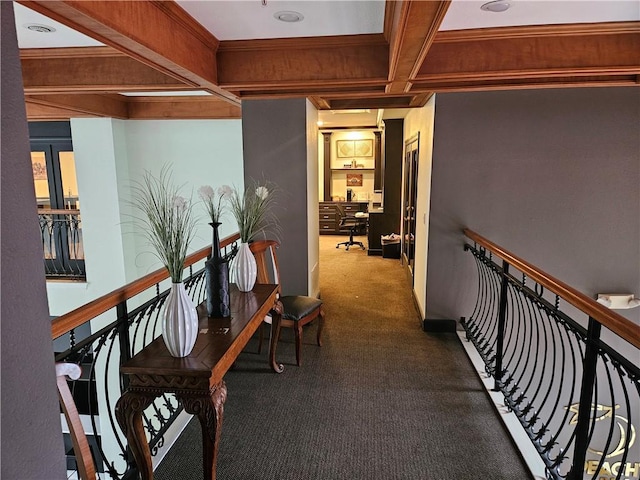 corridor with coffered ceiling, beam ceiling, crown molding, and carpet