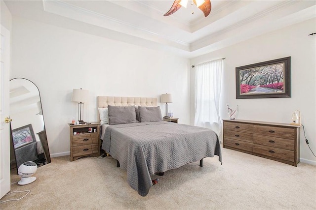 carpeted bedroom with ceiling fan and a raised ceiling