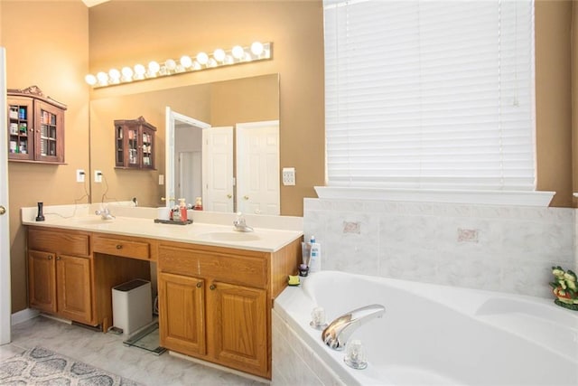 bathroom featuring tiled tub and vanity