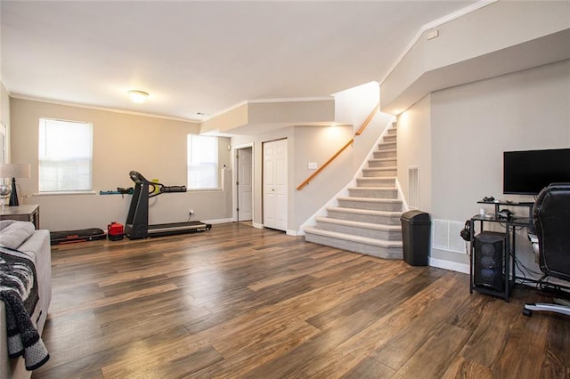 workout area with a healthy amount of sunlight, dark hardwood / wood-style flooring, and crown molding