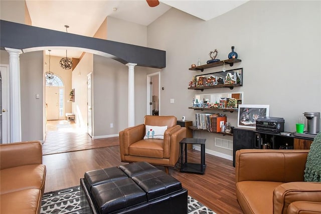 living room featuring hardwood / wood-style flooring, decorative columns, and a chandelier