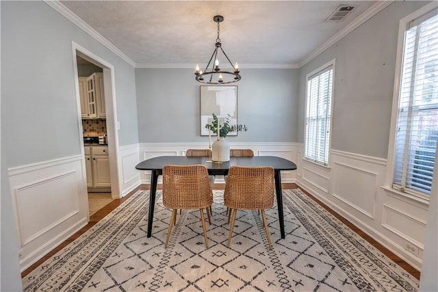 1510 Ridgemill Ter, Dacula, GA 30019 - dining area with light wood finished floors, a chandelier, ornamental molding, a decorative wall, and a wainscoted wall