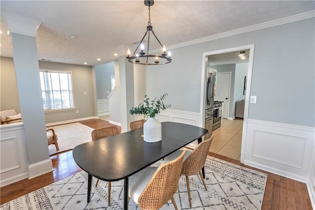 1510 Ridgemill Ter, Dacula, GA 30019 - dining room with a chandelier, wainscoting, light wood-style flooring, ornamental molding, and stairway