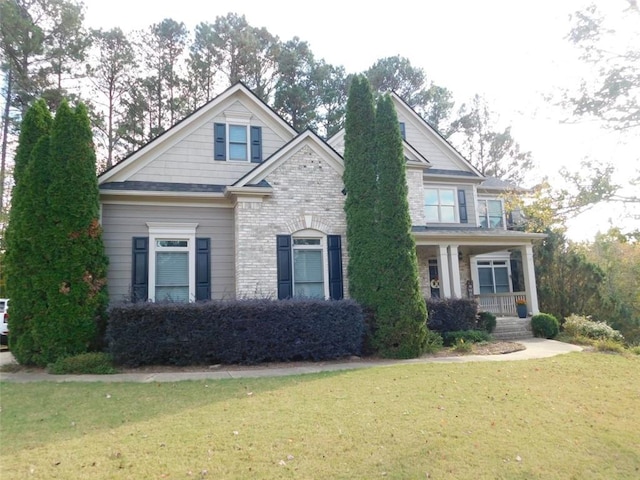 craftsman-style home featuring covered porch and a front yard