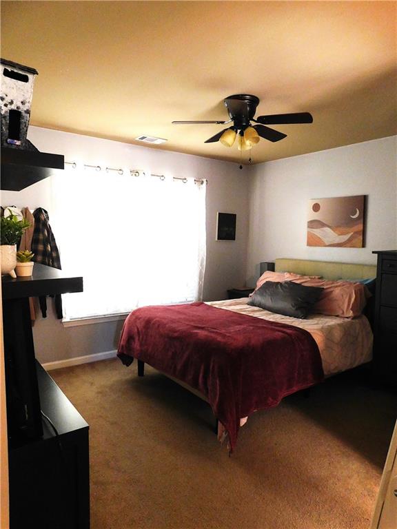 bedroom with carpet flooring, multiple windows, and ceiling fan