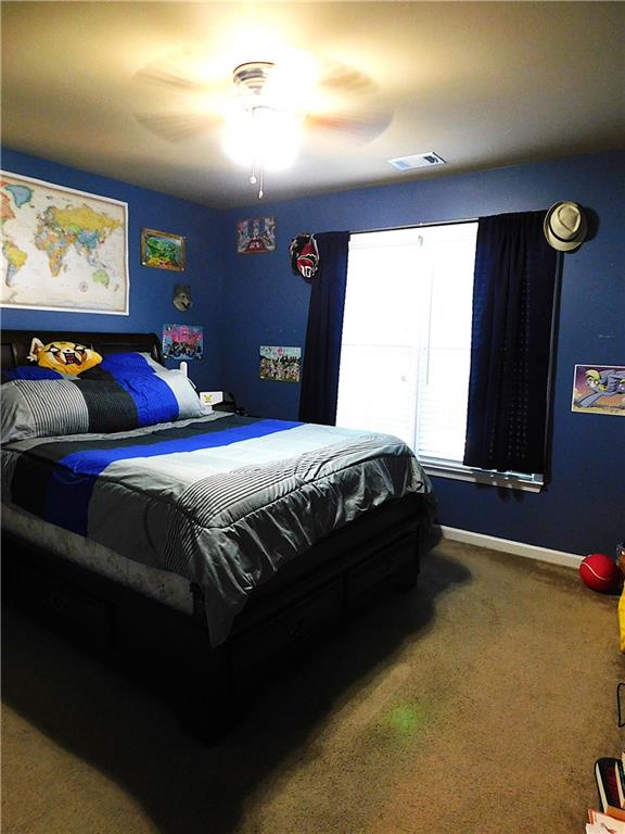 bedroom featuring ceiling fan and carpet