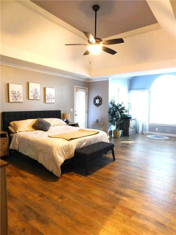 bedroom featuring hardwood / wood-style floors, ceiling fan, and multiple windows