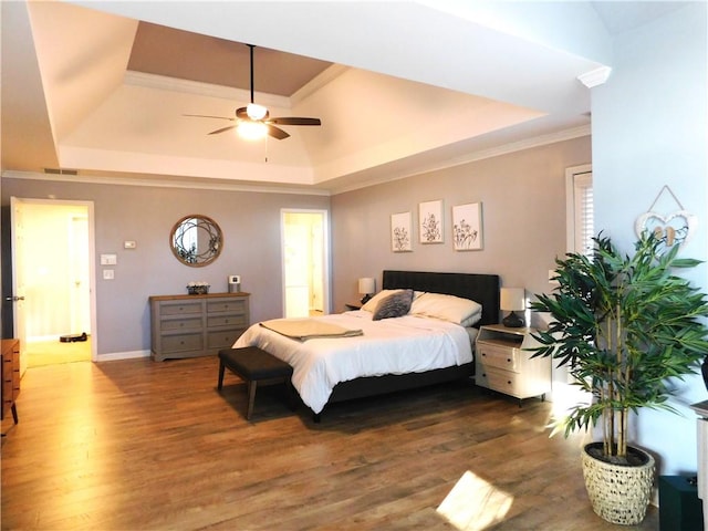 bedroom with ceiling fan, dark hardwood / wood-style flooring, a raised ceiling, and crown molding