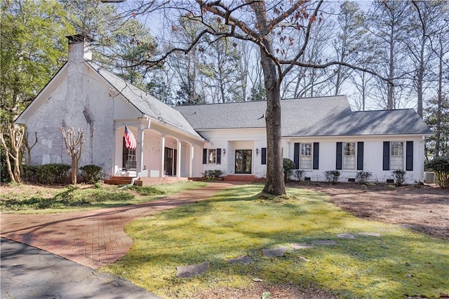 view of front of home featuring crawl space, a chimney, and a front yard