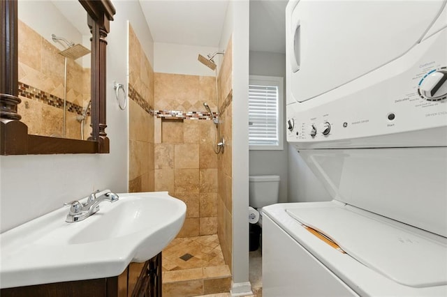 314 Spring Falls Dr, Lawrenceville, GA 30045 - bathroom with stacked washer and clothes dryer, vanity, and tiled shower