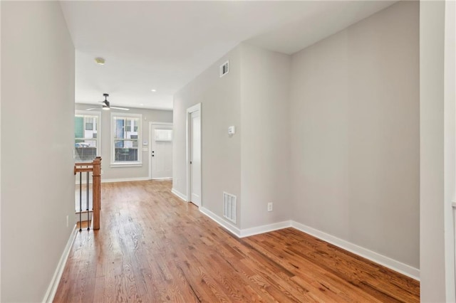 hall with light wood-style floors and baseboards