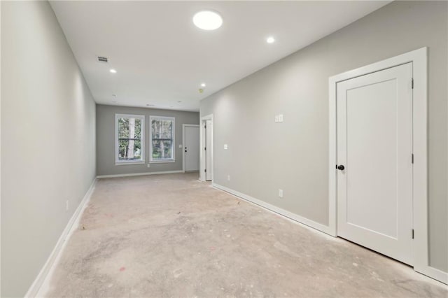 empty room featuring baseboards, concrete flooring, and recessed lighting