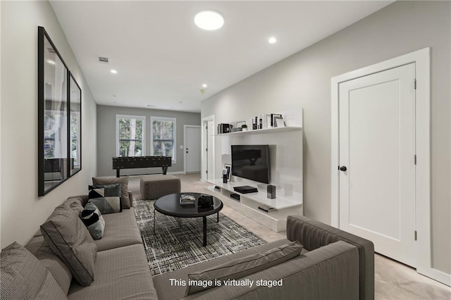 living area featuring light carpet and recessed lighting