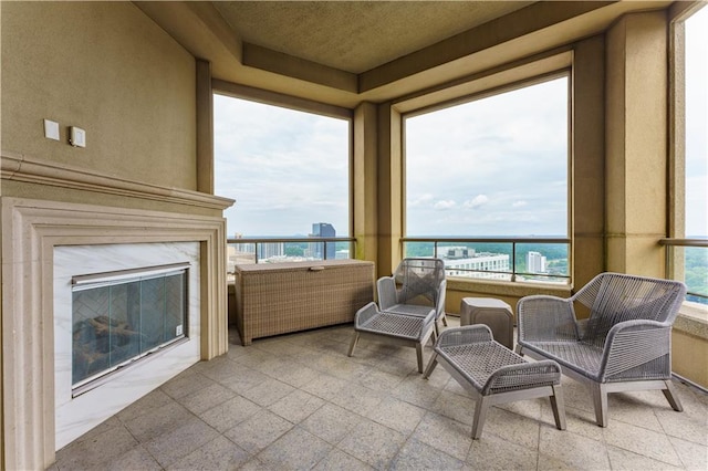 sunroom / solarium with a premium fireplace, a water view, and a wealth of natural light