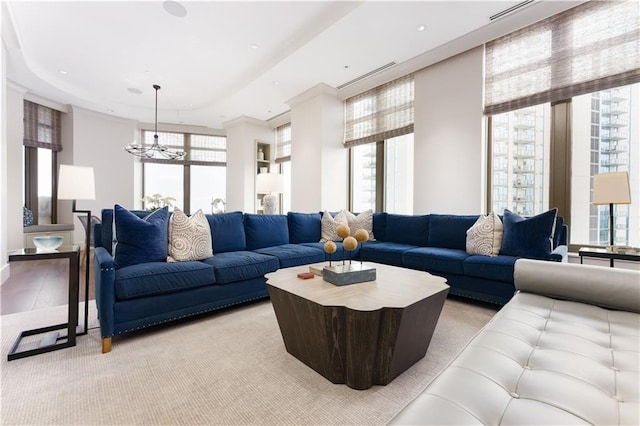 living room with a tray ceiling and a chandelier