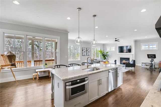 2304 Isla Run, Woodstock, GA 30188 - kitchen featuring a sink, stainless steel appliances, a warm lit fireplace, healthy amount of natural light, and recessed lighting