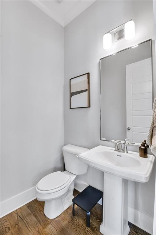 2304 Isla Run, Woodstock, GA 30188 - bathroom with toilet, baseboards, and wood finished floors