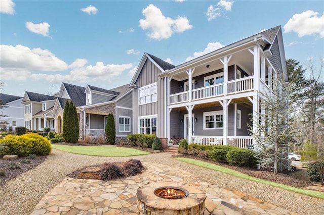 2304 Isla Run, Woodstock, GA 30188 - view of front of home featuring a balcony, board and batten siding, an outdoor fire pit, and covered porch
