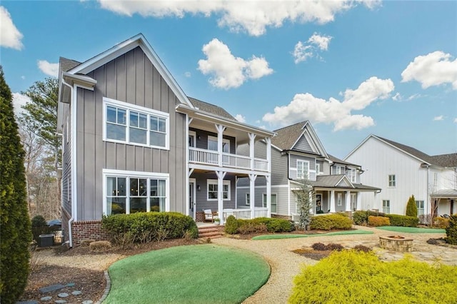 2304 Isla Run, Woodstock, GA 30188 - back of house featuring board and batten siding, an outdoor fire pit, covered porch, and a balcony