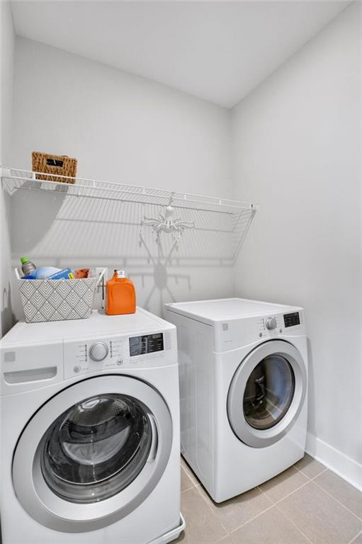 2304 Isla Run, Woodstock, GA 30188 - washroom featuring washing machine and clothes dryer, baseboards, and light tile patterned flooring