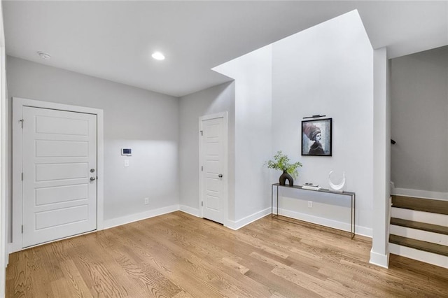 2304 Isla Run, Woodstock, GA 30188 - entrance foyer featuring light wood finished floors, baseboards, and stairway