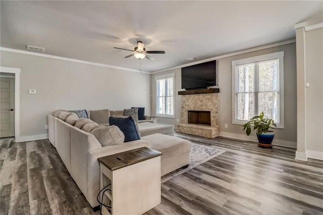 569 White Oak Way, Monroe, GA 30655 - living room with dark hardwood / wood-style flooring, crown molding, a healthy amount of sunlight, and a stone fireplace