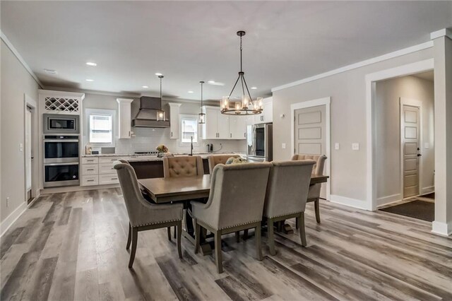 569 White Oak Way, Monroe, GA 30655 - dining area with crown molding, hardwood / wood-style floors, and a chandelier