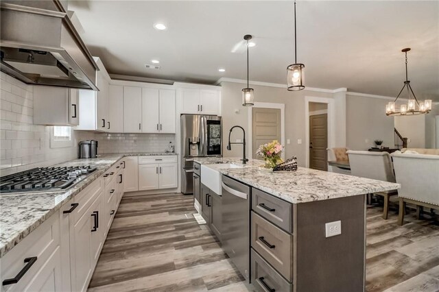 569 White Oak Way, Monroe, GA 30655 - kitchen with an island with sink, white cabinets, stainless steel appliances, and decorative light fixtures
