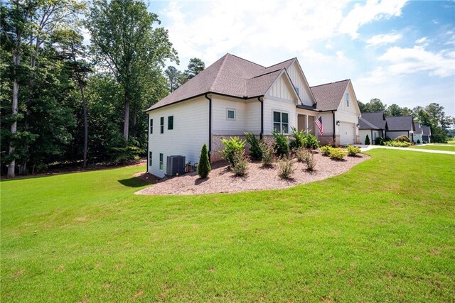 569 White Oak Way, Monroe, GA 30655 - view of side of home featuring a garage, cooling unit, and a lawn