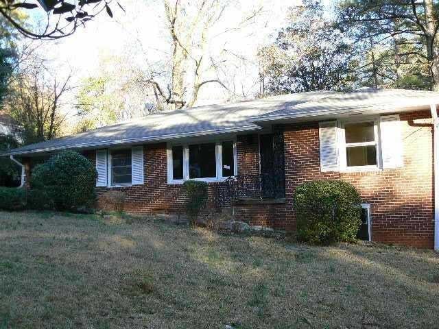 view of front of house with brick siding and a front lawn