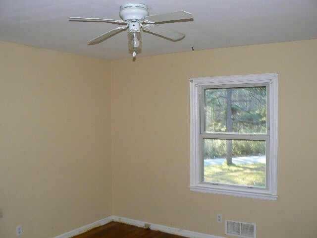 empty room with visible vents, baseboards, and a ceiling fan