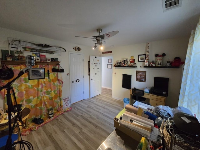 living room with light hardwood / wood-style flooring and ceiling fan