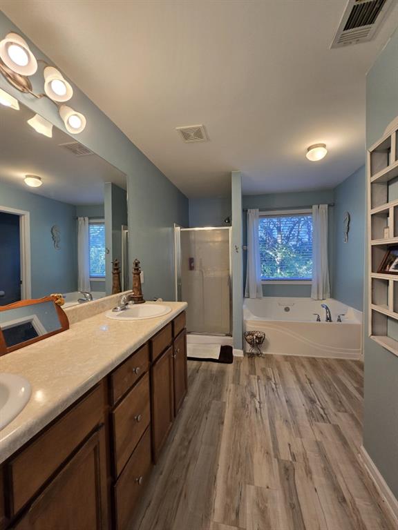 bathroom with vanity, hardwood / wood-style floors, and independent shower and bath