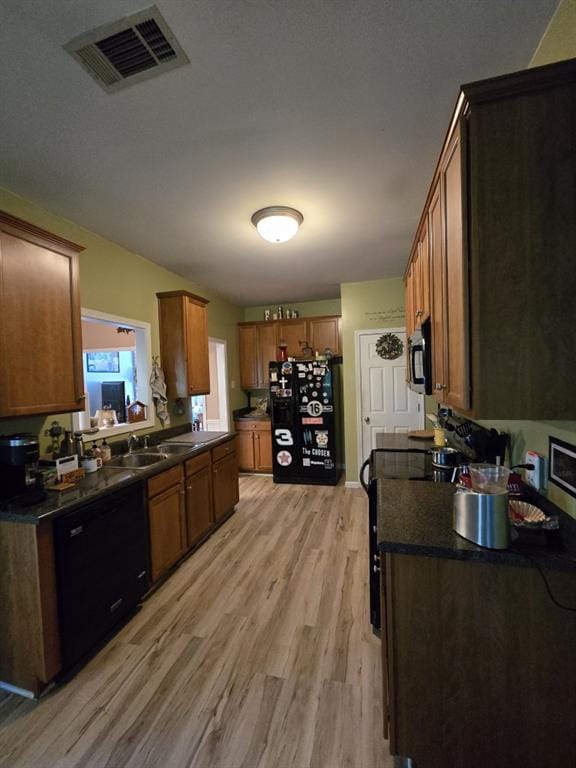 kitchen featuring sink, light hardwood / wood-style floors, and black appliances