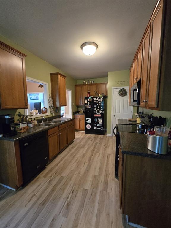 kitchen with sink, light hardwood / wood-style flooring, and black appliances