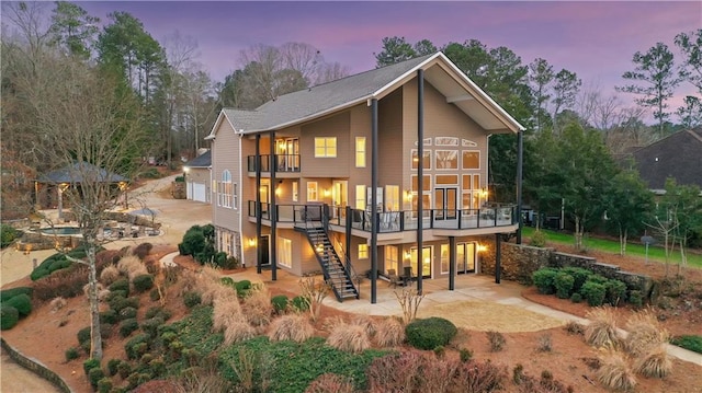 back of property featuring a garage, a patio, stairway, and driveway