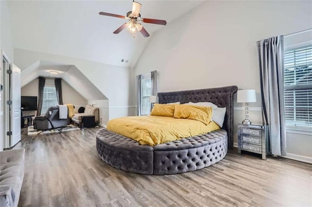 bedroom with hardwood / wood-style flooring, ceiling fan, and high vaulted ceiling