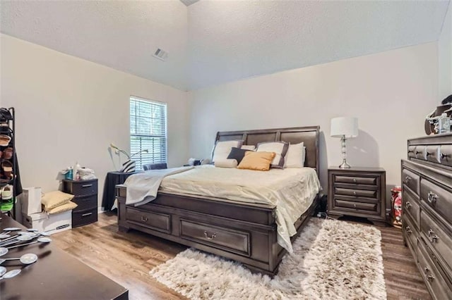 bedroom featuring hardwood / wood-style floors and a textured ceiling