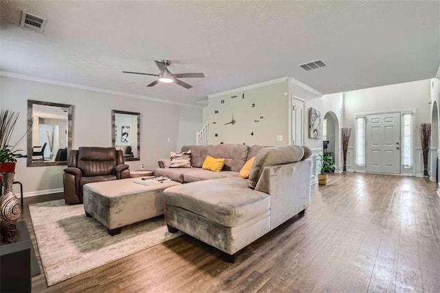 living room with crown molding, wood-type flooring, and ceiling fan