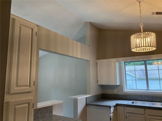 kitchen featuring sink, a chandelier, and pendant lighting