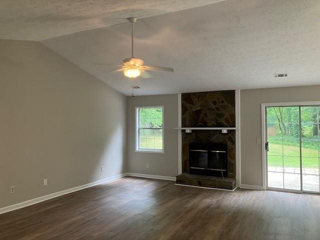 unfurnished living room with a stone fireplace, plenty of natural light, dark hardwood / wood-style flooring, and lofted ceiling