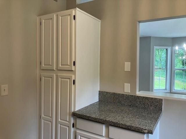 kitchen featuring white cabinets and dark stone counters