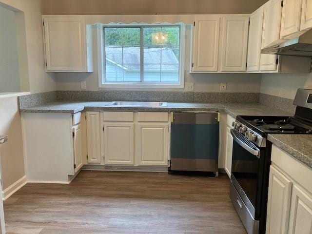 kitchen with light hardwood / wood-style floors, white cabinets, appliances with stainless steel finishes, and sink