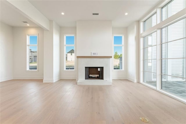 260 Guild Ln, Fayetteville, GA 30214 - unfurnished living room featuring visible vents, baseboards, recessed lighting, a fireplace with raised hearth, and light wood-style flooring