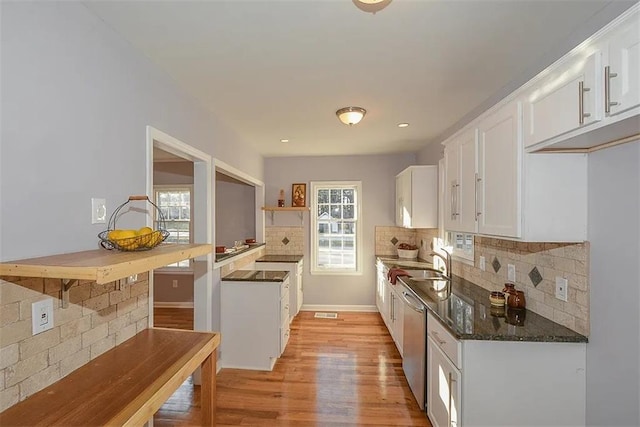 1496 S Hairston Rd, Stone Mountain, GA 30088 - kitchen with stainless steel dishwasher, white cabinets, tasteful backsplash, light wood finished floors, and a sink