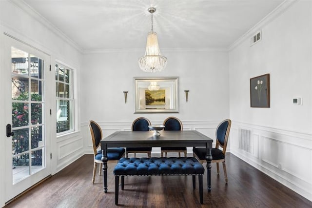 dining area featuring visible vents, dark wood-style floors, an inviting chandelier, and ornamental molding