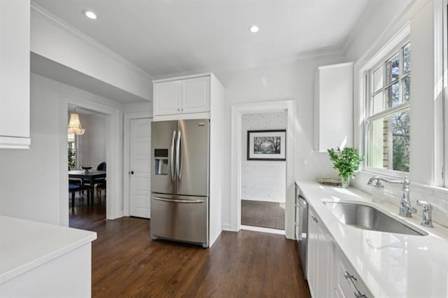 kitchen featuring light countertops, white cabinetry, a sink, appliances with stainless steel finishes, and dark wood-style flooring